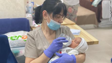 Ein Kindermädchen in einer Leihmutterschaftsklinik füttert ein neugeborenes Baby, das darauf wartet, von seinen neuen Eltern abgeholt zu werden.