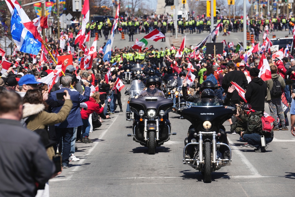 Demonstranten jubeln, als Autofahrer während einer Demonstration vorbeifahren und Teil einer Demonstration im Wohnwagenstil sind "Donnergrollen"in Ottawa, Samstag, 30. April 2022