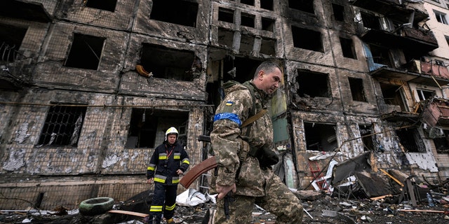 Ukrainische Soldaten und Feuerwehrleute durchsuchen ein zerstörtes Gebäude nach einem Bombenanschlag in Kiew, Ukraine, Montag, 14. März 2022 (AP Photo/Vadim Ghirda)