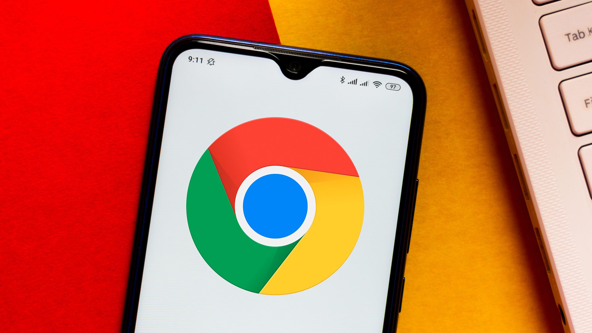 Das Google Chrome-Logo, das auf einem Android-Smartphone angezeigt wird und auf einer orange-roten Oberfläche ruht
