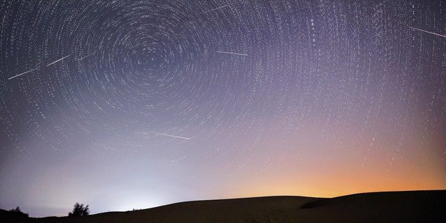 Das zusammengesetzte Bild, das am 13. August 2021 aufgenommen wurde, zeigt den Nachthimmel während des Meteoritenschauers der Perseiden über dem ökologischen Demonstrationsgebiet Ingbe in der Kubuki-Wüste, Autonome Region Innere Mongolei in Nordchina. 
