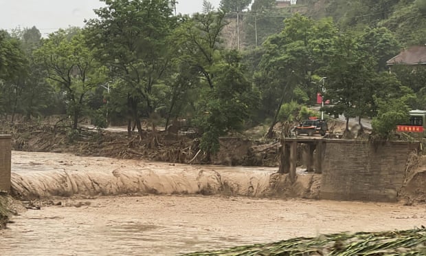 Ein Auto steht neben einem Teil einer Brücke, die von Hochwasser in Qingyang im Nordwesten Chinas weggespült wurde