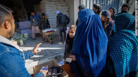 Eine afghanische Frau erhält ihre monatliche Ration an Grundnahrungsmitteln für ihre Familie von einer Verteilungsstelle des Welternährungsprogramms im Distrikt Jay Rais, westlich von Kabul.