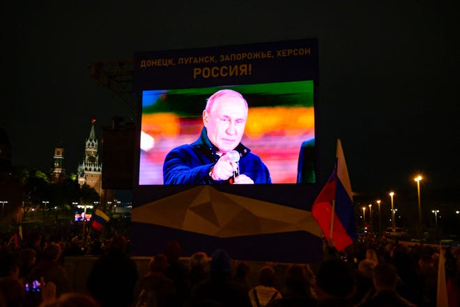 Der russische Präsident Wladimir Putin erscheint auf einem Bildschirm, während er vor einer Menschenmenge und einem Konzert spricht, das die Annexion von vier von russischen Streitkräften besetzten Regionen der Ukraine markiert – Lugansk, Donezk, Cherson und Saporischschja – im Zentrum von Moskau am 30. September 2022.