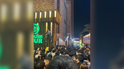 Ein Mann wird am 29. Oktober in Itaewon, Seoul, gesehen, wie er auf ein Gebäude klettert, um der Menge zu entkommen. 