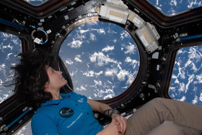 Astronautin Samantha Cristoforetti blickt durch das Fenster der Kuppel der Raumstation auf das Meer und die Wolken darunter