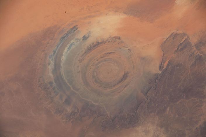 Die Landschaft zeigt konzentrische Kreise in der rotbraunen Wüste