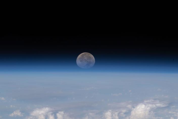 Der Mond fehlt unter dem Horizont der Erde vor der Schwärze des Weltraums