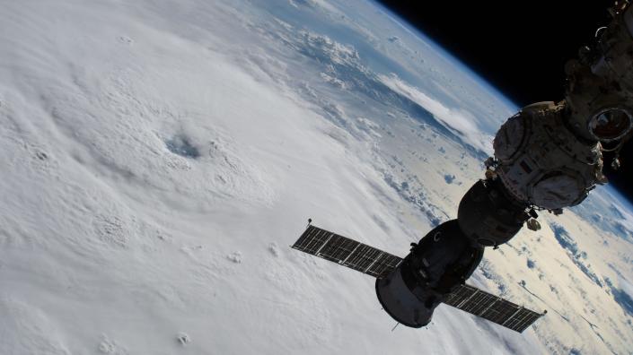 Ein Raumstationsmodul über dem Hurrikan auf dem Boden darunter