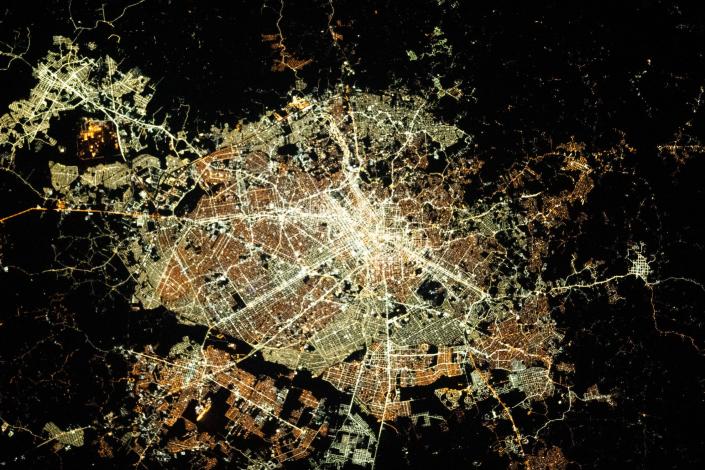 Kreisförmige Stadt beleuchtet bei Nachtansicht aus dem Weltraum
