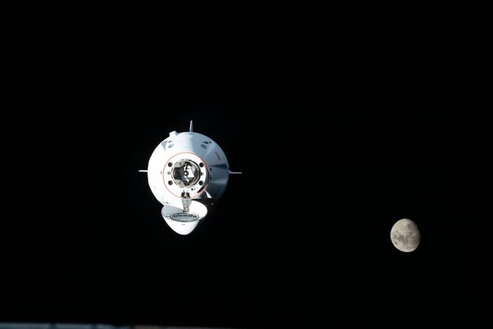 Dragon-Raumschiff-Crew fliegt im schwarzen Raum mit Mond im Hintergrund