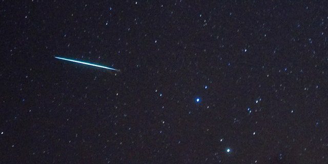 Ein Meteor (L) aus dem Meteorschauer der Geminiden dringt am 12. Dezember 2009 über Southwold, New York, an den Sternen Castor und Pollux (zwei helle Sterne, R) vorbei in die Erdatmosphäre ein.